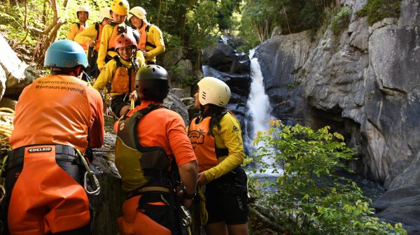 Visitors enjoy waterfalls and cairns in the rainforest at Crystal Canyon