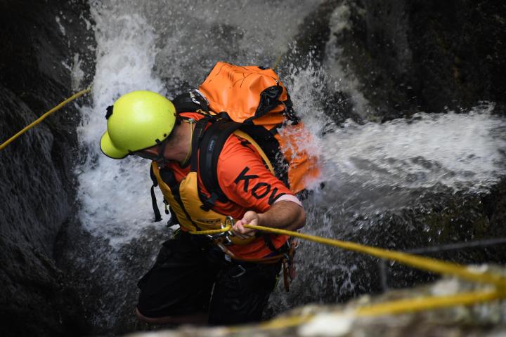 a person exploring while abseiling cairns waterfalls at Spillway Canyon