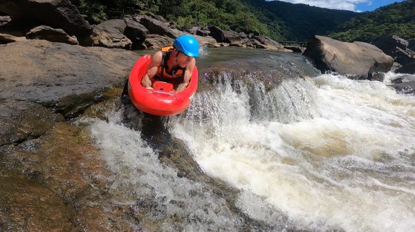 man experiencing riverboarding at cairns waterfalls