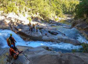 a group of people walking along a river next to a body of water